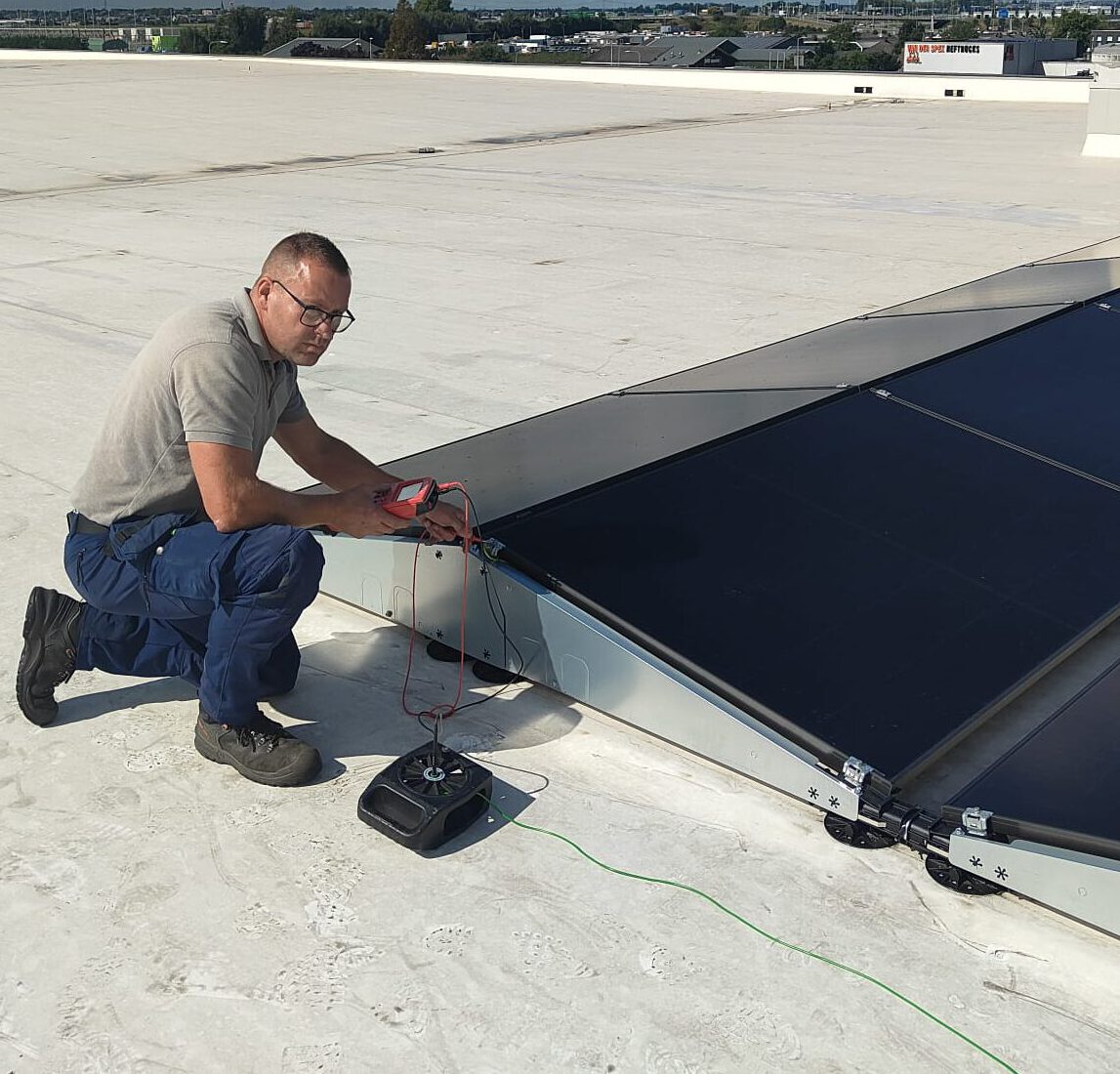 paul oplever Inspectie van zonnepaneel-installatie plat dak met Dc tester